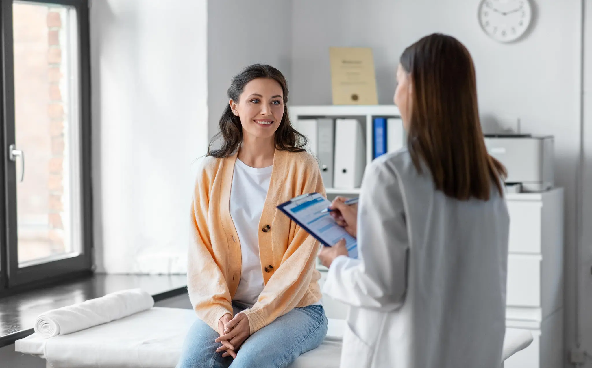 Una médica conversa con una paciente en el consultorio antes de su estudio